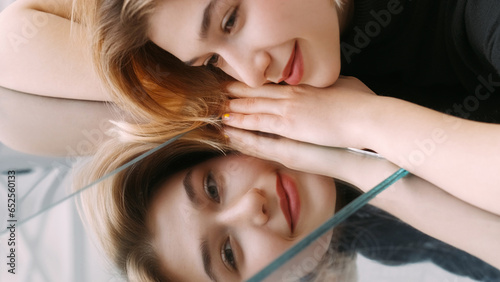 Smiling face. Mirror reflection. Happy calm attractive woman lying on repulse surface dreaming pleasant thoughts free space.