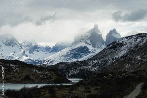 Behold the awe-inspiring majesty of Torres del Paine  where monumental granite spires pierce through a shroud of swirling clouds. In this captivating image  the iconic  Towers of Blue  in Chile s Pata