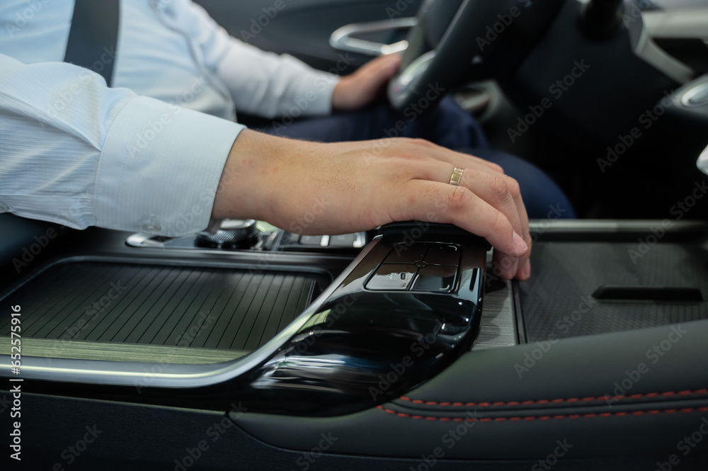 Close-up of a man's hands on the automatic transmission of a modern car. Close-up of a man's hands on the automatic transmission of a modern car.