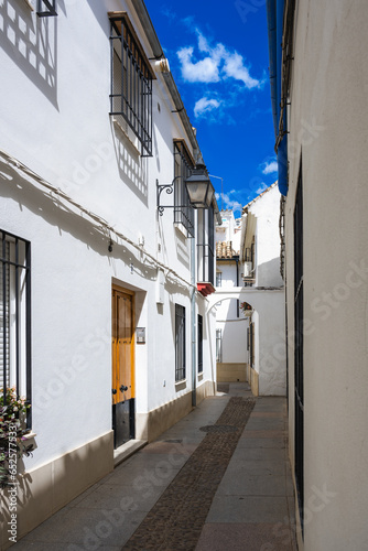 Fototapeta Naklejka Na Ścianę i Meble -  Vertical View of a Traditional Andalusian Alleyway in Cordoba's Jewish Quarter, Spain