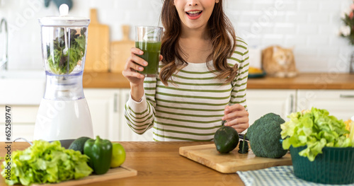 Portrait of beauty healthy asian woman making green vegetables detox cleanse and green fruit smoothie with blender.young girl drinking glass of smoothie, fiber, chlorophyll in kitchen.Diet, healthy