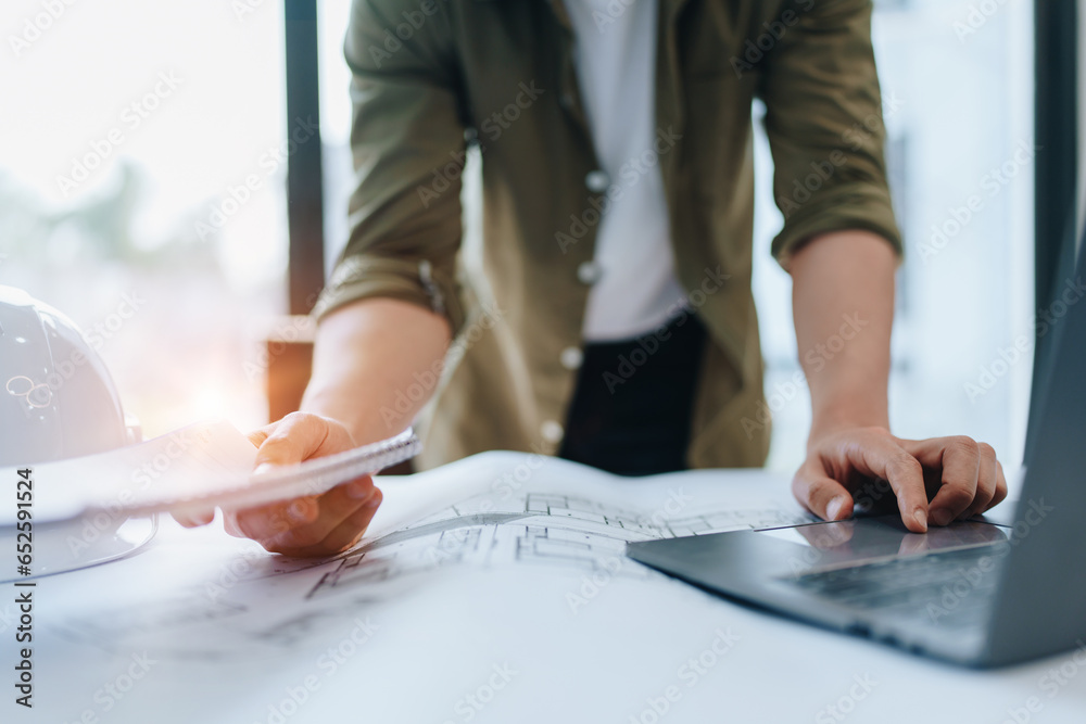 © Jirapong - engineering department with work design structure building or house using blueprint computer at working.