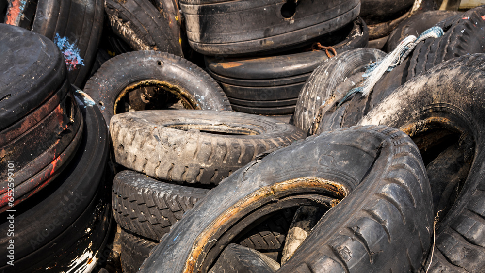 old used car tire stack pile. Piles of used tires from cars and trucks drill holes for use at docks.