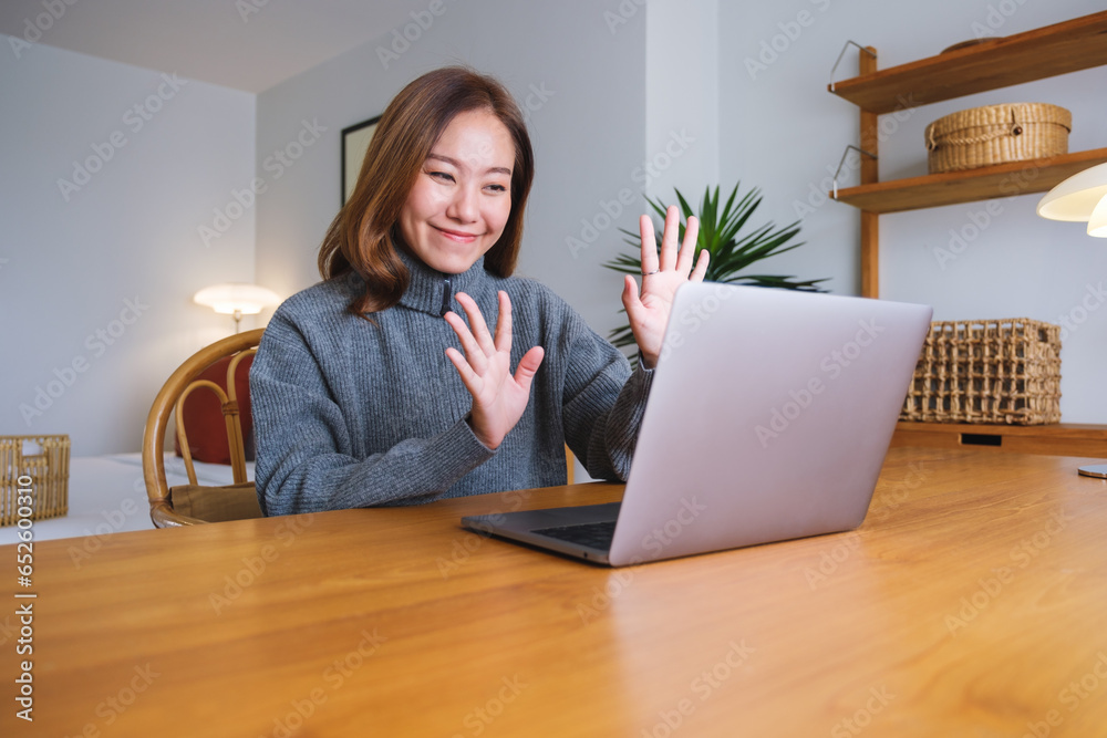 Portrait image of a young woman using laptop computer for video call and working online at home Portrait image of a young woman using laptop computer for video call and working online at home