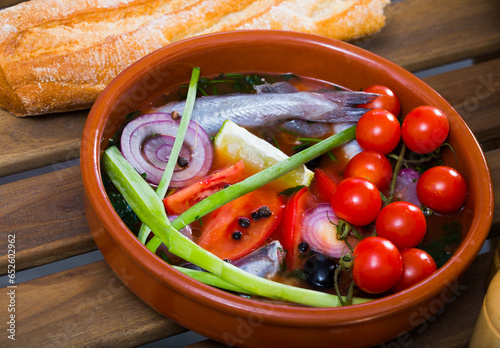 Fisherman's broth prepared with poutassou and small sea fish, served with cherry tomatoes photo