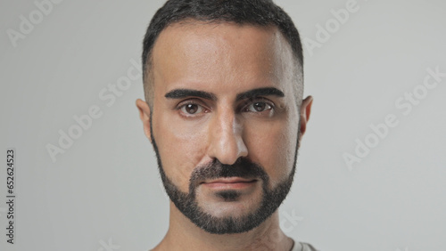 Handsome person look at camera close up. Young adult man face portrait. Stylish 30s guy on isolated white background. Attractive male model. Modern millennial people. Brutal bearded style. Barber shop