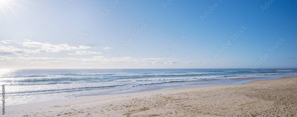 Soft pastel morning colors seascape as sun rises over ocean. Concept background for summer vacation or business travel. Inspirational relaxing scenery of seashore. Empty beach seascape copyspace