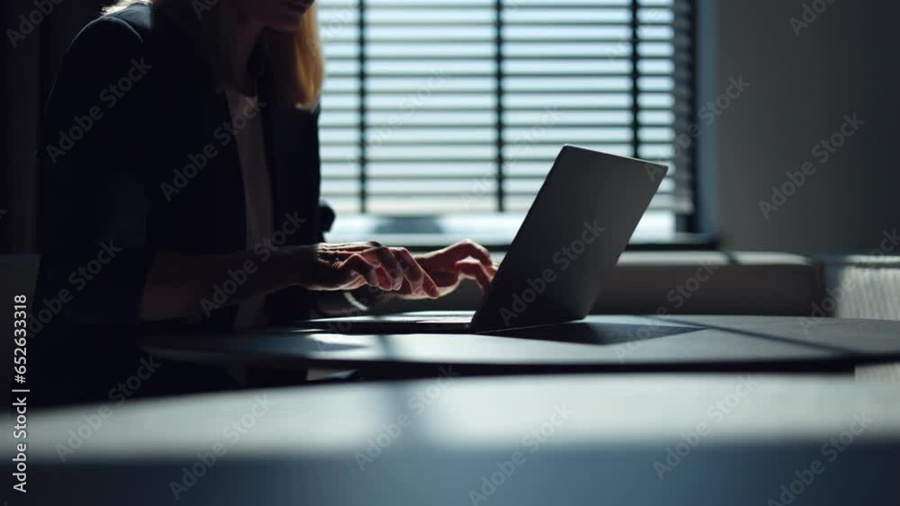 Close up of female office worker with blond hair swiftly pressing buttons on keyboard while working at round table. Caucasian woman in formal outfit typing notes, emails and data on portable laptop.