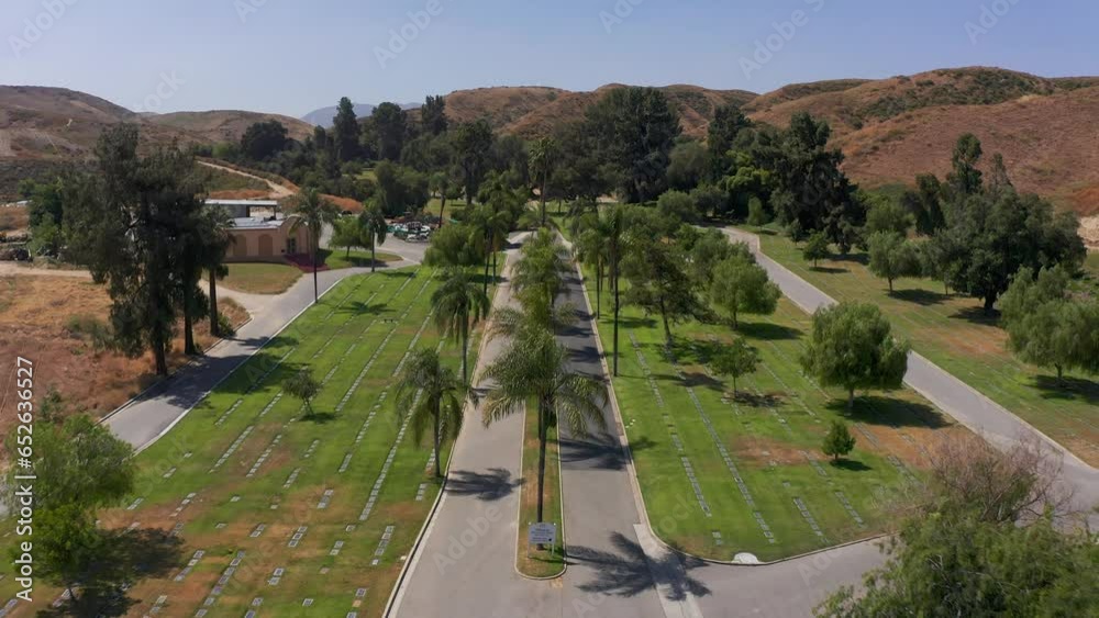 Low aerial shot flying over palm trees that line the main road of a mortuary in California. 4K Low aerial shot flying over palm trees that line the main road of a mortuary in California. 4K