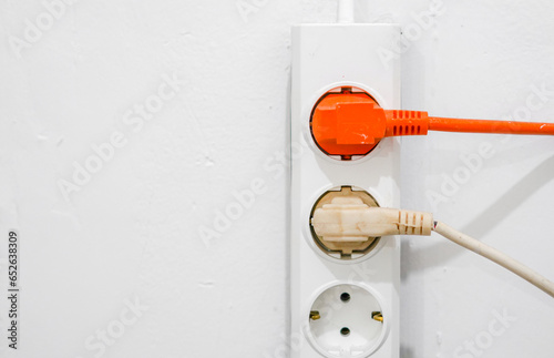 electrical outlet on a wall, electrical power switch, electric plug on a wall, orange electrical plug