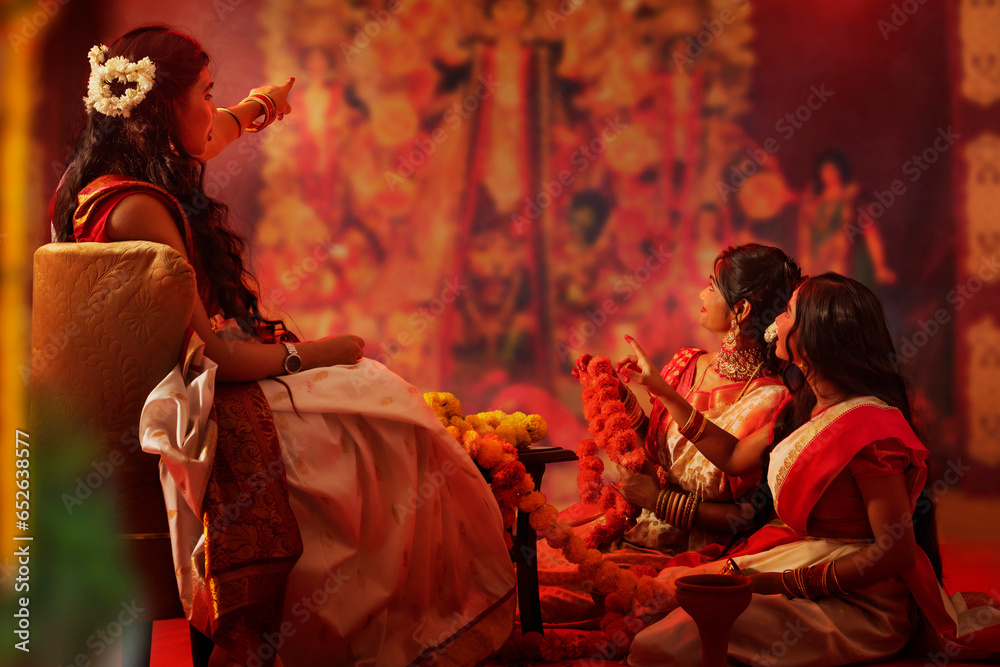 Bengali family making flower garland on the occasion of Durga Puja