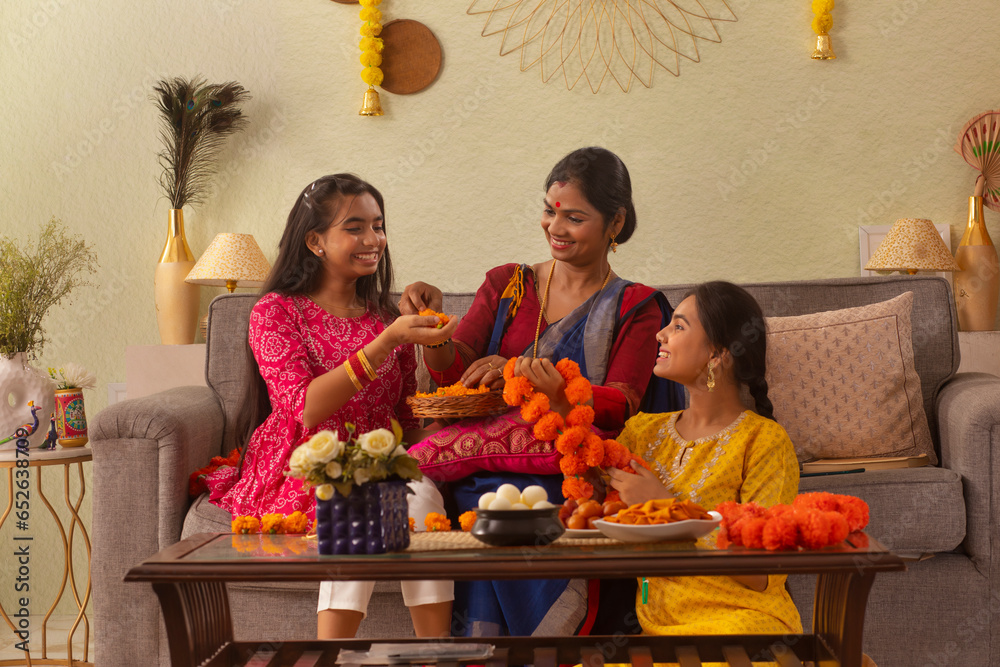 Foto de Bengali family making flower garland at home on the occasion of