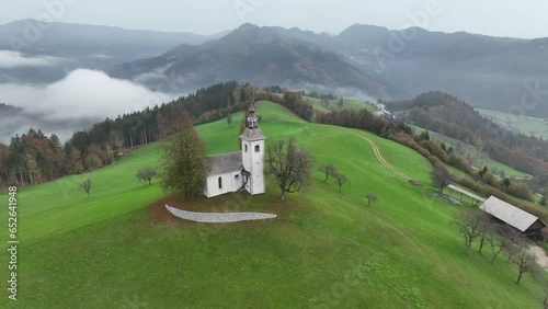Aerial view of Saint Thomas church at sunrise in the fog, Skofja Loka, Upper Carniola, Slovenia  photo