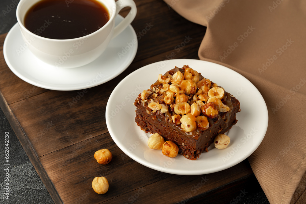 Brownie cake with nuts topping on plate close up Brownie cake with nuts topping on plate close up
