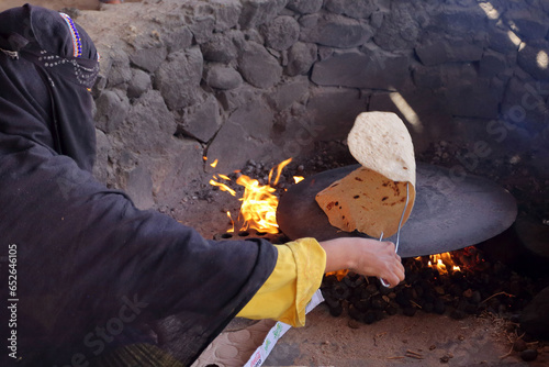 Photography Making traditional  bedouin flat bread on an open fire in Egypt.
