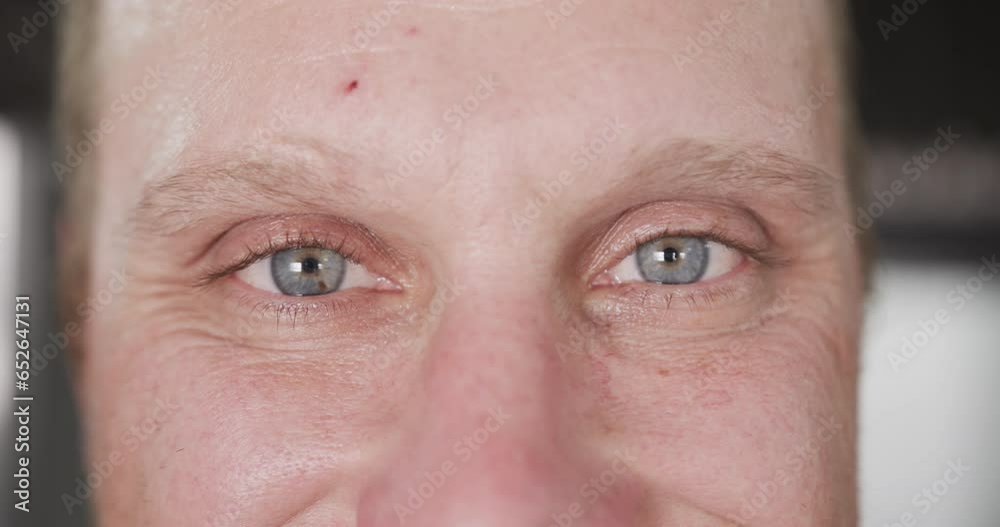Portrait close up of blue eyes of happy caucasian male chef in smiling in kitchen, slow motion Portrait close up of blue eyes of happy caucasian male chef in smiling in kitchen, slow motion