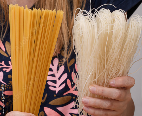 Makaron klasyczny spaghetti i makaron ryżowy trzymany w dłoniach 