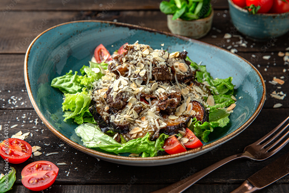 Warm salad of mushrooms, almonds, veal tenderloin, vegetables and Parmesan cheese Menu for a restaurant. Beautiful composition on wooden boards. Warm salad of mushrooms, almonds, veal tenderloin, vegetables and Parmesan cheese Menu for a restaurant. Beautiful composition on wooden boards.