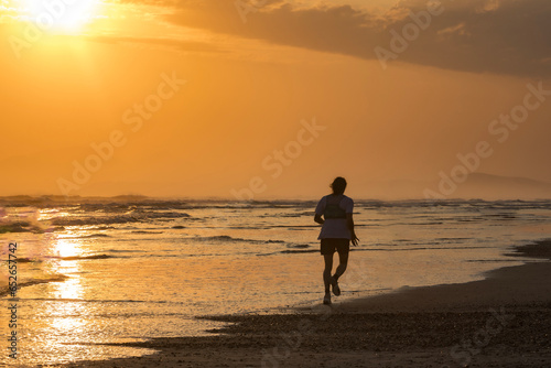 The joy of running on a golden beach at sunset