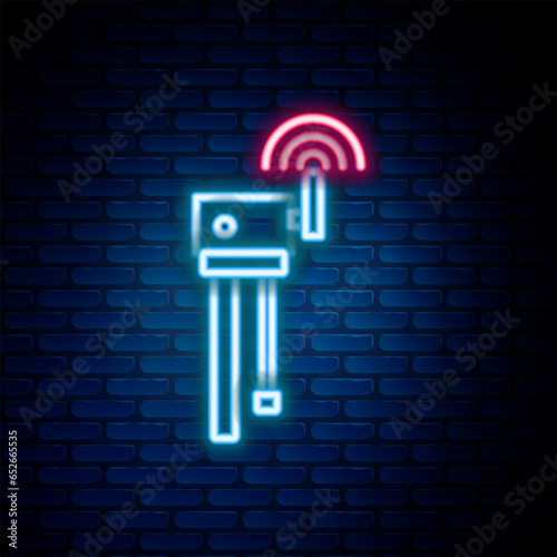 Glowing neon line Router and wi-fi signal symbol icon isolated on brick wall background. Wireless ethernet modem router. Computer technology internet. Colorful outline concept. Vector