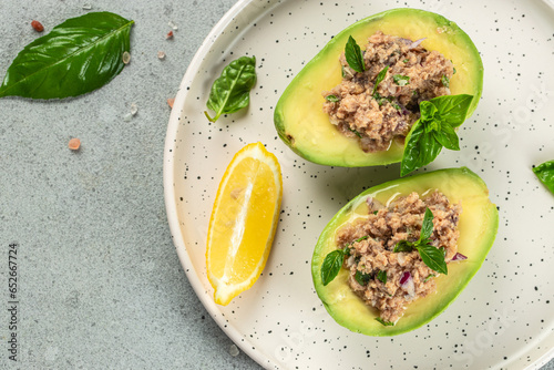 avocado stuffed with tuna on white plate. organic healthy products. Detox and clean diet concept. place for text, top view