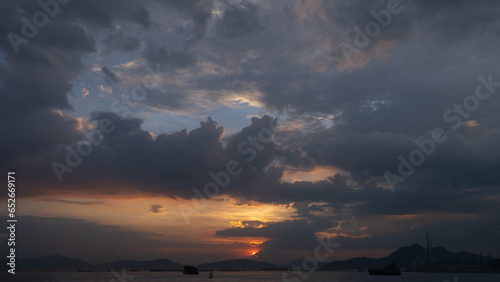 Beautiful violet sunset sky with clouds and deep orange sun sea view