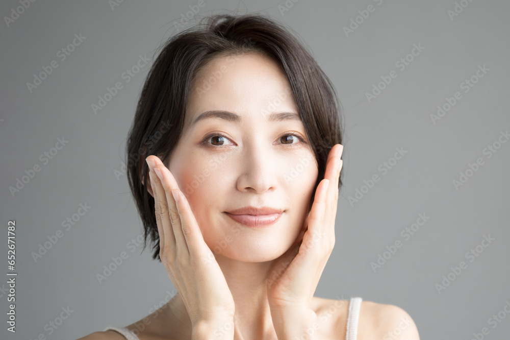 Asian woman in beauty or other beauty image with hands on cheeks (Japanese)Looking at camera Frontal Asian woman in beauty or other beauty image with hands on cheeks (Japanese)Looking at camera Frontal