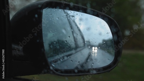 Side Mirror View of Car Driving in Heavy Rain
