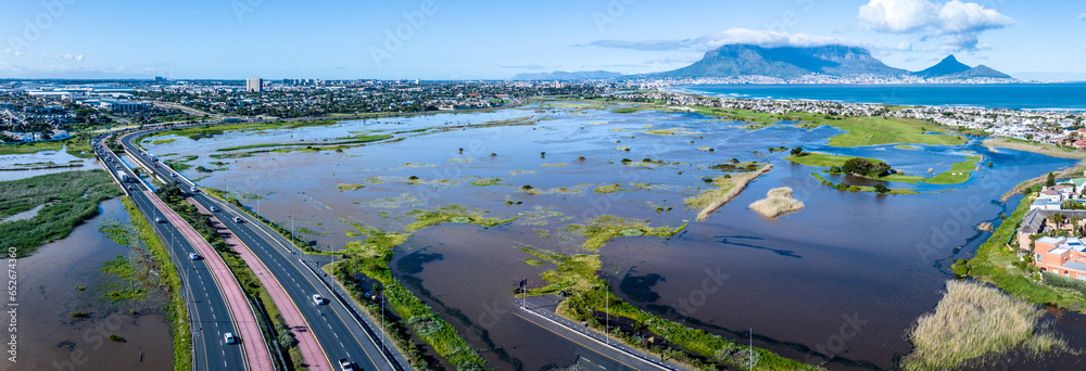 Obraz premium Panoramic view of storm flooding in Cape Town, South Africa, the Diep River breaking its banks after an exceptionally deep cut-off low pressure system hit the Western Cape. High level view.