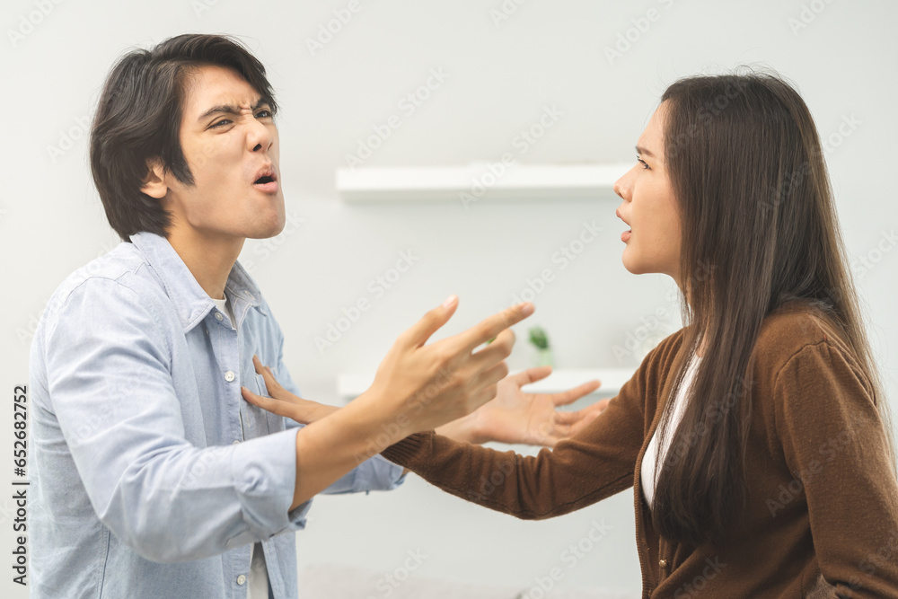 Asian young couple fight standing on white background, relationship in trouble. Different angry, use emotion shouting at each other. Argue husband has expression of disappointment and upset with wife. Asian young couple fight standing on white background, relationship in trouble. Different angry, use emotion shouting at each other. Argue husband has expression of disappointment and upset with wife.