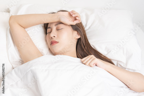Sweet dreams, expression face stress asian young woman, girl sleeping in comfortable bed lying on soft pillow resting, keeping eyes closed while with covered blanket in cozy white bed in the morning.