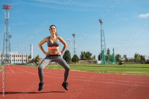 Obraz na płótnie Beautiful woman training on the tracks on a sunny morning w salonie