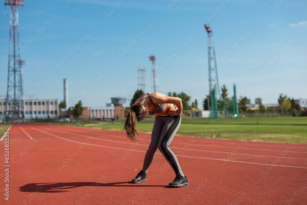Beautiful woman training on the tracks on a sunny morning
