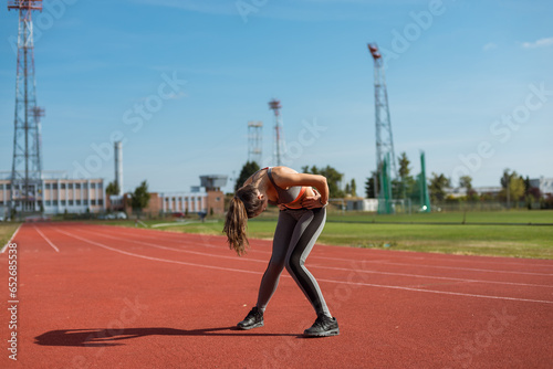 Beautiful woman training on the tracks on a sunny morning 