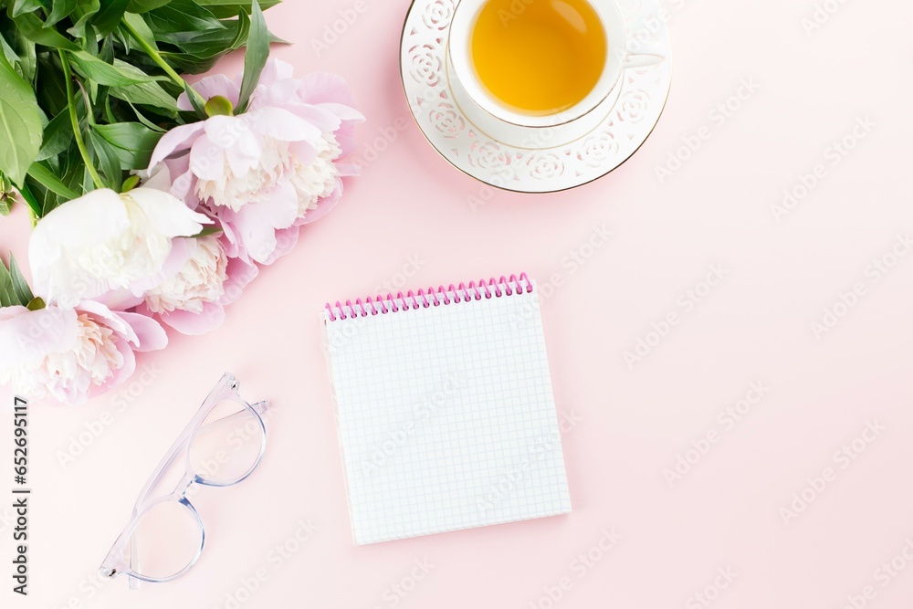 Peony Flowers, Tea, Eyeglasses and Blank Notepad on Pink Background Peony Flowers, Tea, Eyeglasses and Blank Notepad on Pink Background