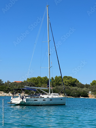 White yacht in the bay of the Adriatic Sea. Holidays on the open sea on a small boat. Boat with a sail near the sea coast.