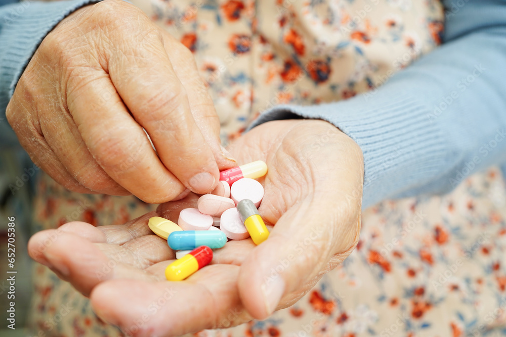 Asian elderly woman holding pill drug in hand, strong healthy medical concept. Asian elderly woman holding pill drug in hand, strong healthy medical concept.