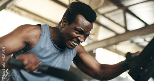 Black man, fitness and cycling at gym in cardio workout, exercise or intense training on machine. African male person on bicycle equipment in sweat or running for muscle, endurance or stamina at club