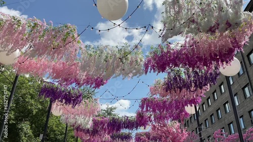 Festival garlands flowers above are blowing in the wind over the pedestrian street. Decorations of the city square for the holiday.