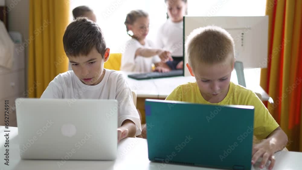 Group of children at school online learning. Teamwork of children with laptop online learning as a team. Children learn together at school to work as team with laptop.Team learning at school in lesson Group of children at school online learning. Teamwork of children with laptop online learning as a team. Children learn together at school to work as team with laptop.Team learning at school in lesson
