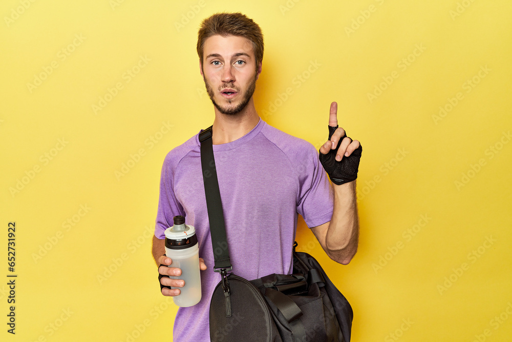 Caucasian athlete with gym gear on yellow having some great idea, concept of creativity. Caucasian athlete with gym gear on yellow having some great idea, concept of creativity.