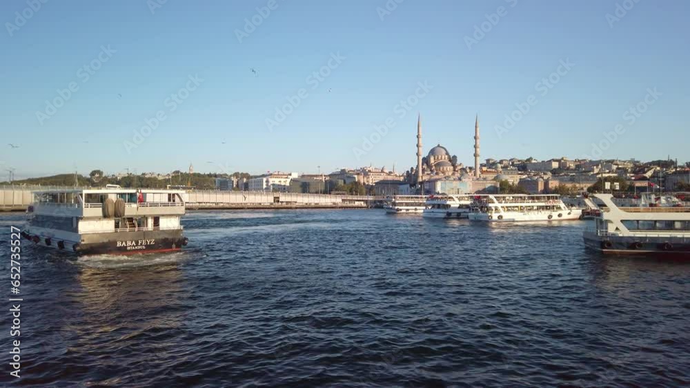 Evening, cinematic slow-mo, a view of Eminonu from a ferry on the Golden Horn in Istanbul. The shot showcases the moving ferries, the cityscape, and the New Mosque (Yeni Camii). Evening, cinematic slow-mo, a view of Eminonu from a ferry on the Golden Horn in Istanbul. The shot showcases the moving ferries, the cityscape, and the New Mosque (Yeni Camii).