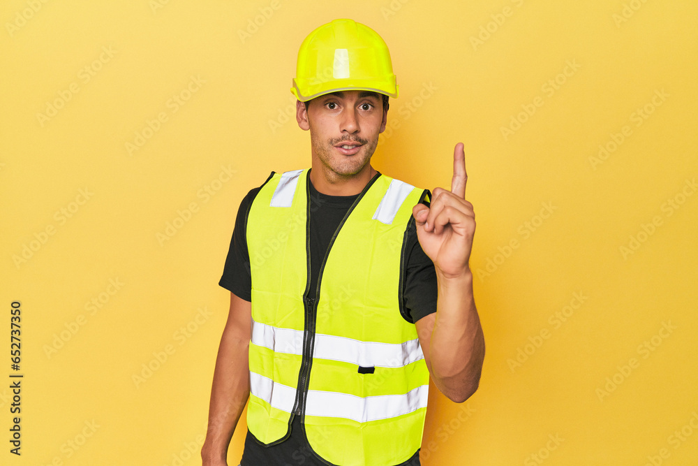 Εκτύπωση καμβά Latino worker in yellow vest and helmet having an idea, inspiration concept
