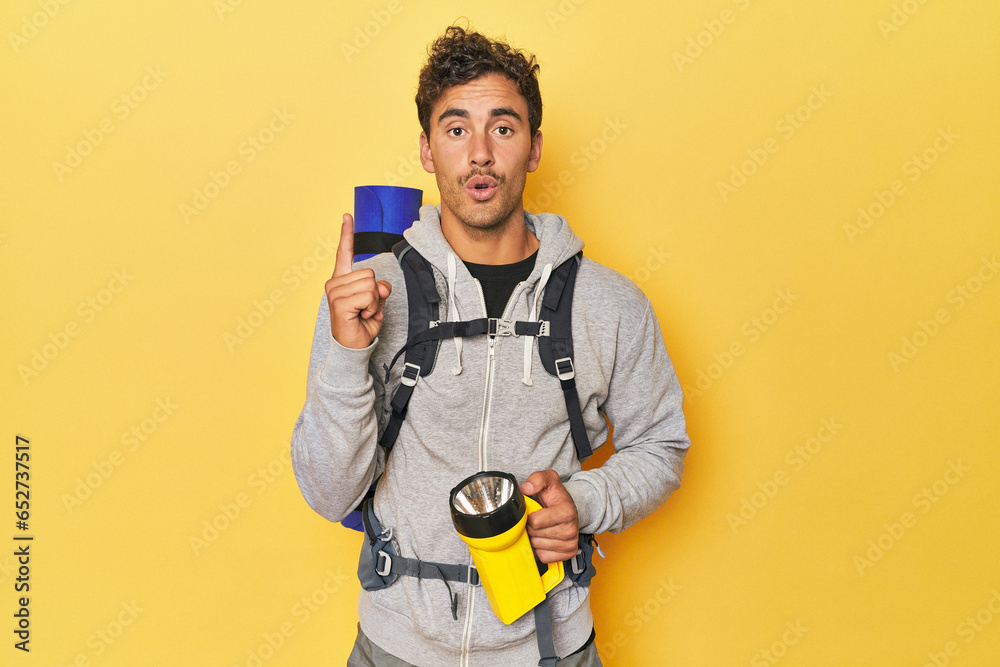 Hiker with backpack and lantern on yellow having some great idea, concept of creativity. Hiker with backpack and lantern on yellow having some great idea, concept of creativity.