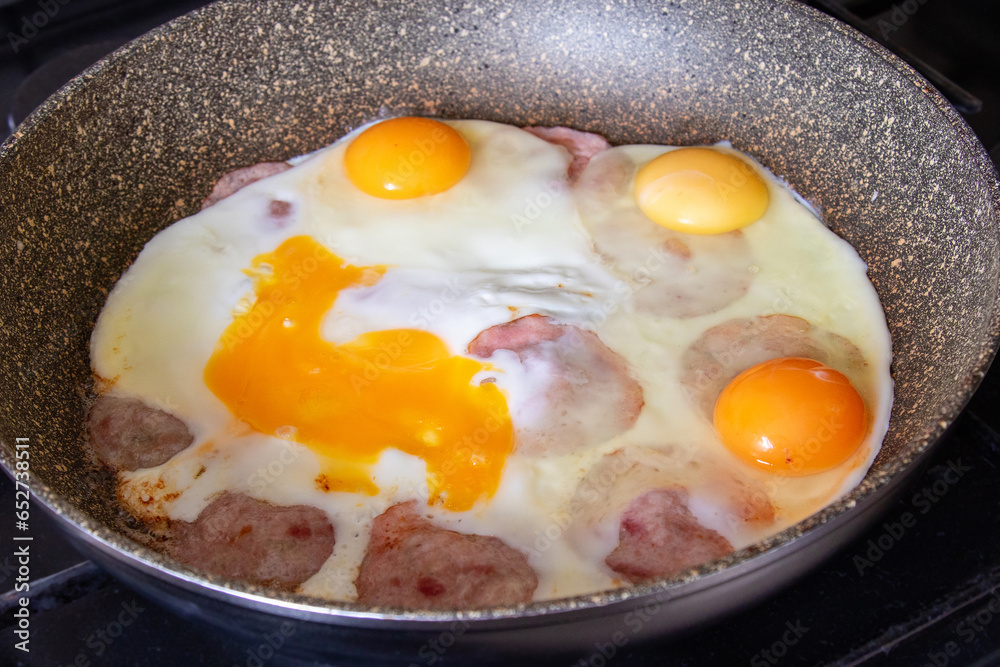 Close-up of a frying pan with hot scrambled eggs and sausage. Freshly prepared breakfast. Close-up of a frying pan with hot scrambled eggs and sausage. Freshly prepared breakfast.