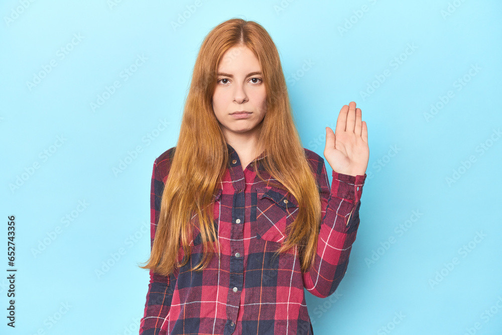 Redhead young woman on blue background smiling cheerful showing number five with fingers. Redhead young woman on blue background smiling cheerful showing number five with fingers.
