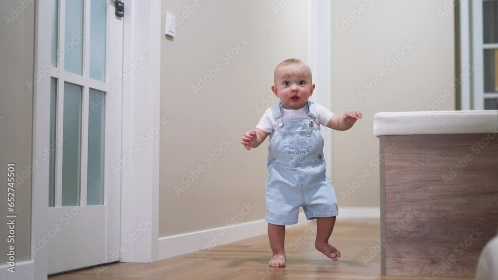 First steps. baby takes first steps at home on the floor. Child learns to walk barefoot on floor. Teaching baby's first steps at home. Happy cheerful kid learning to take first steps.childhood concept First steps. baby takes first steps at home on the floor. Child learns to walk barefoot on floor. Teaching baby's first steps at home. Happy cheerful kid learning to take first steps.childhood concept