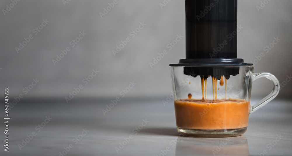 Aeropress coffee close-up, coffee drops pours trought aeropress to cup, gray background - obrazy, fototapety, plakaty 