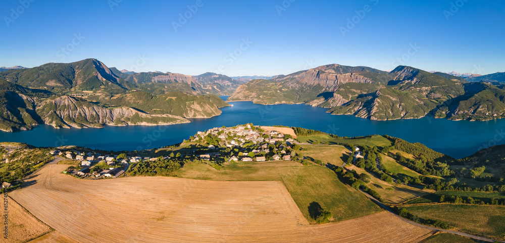 Panoramic aerial view of Serre-Poncon lake with Le Sauze-du-Lac village. Durance Valley in summer. Hautes-Alpes (Alps), France - obrazy, fototapety, plakaty 