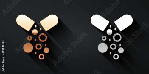 Gold and silver Poisoned pill icon isolated on black background. Pill with toxin. Dangerous drug. Long shadow style. Vector